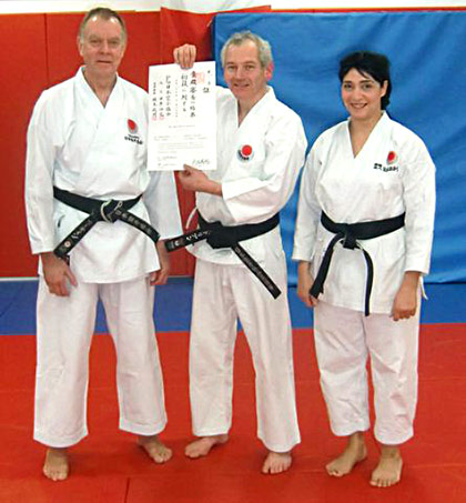 Adrian Thomas (pictured centre) receives his 1st Dan JKA Diploma